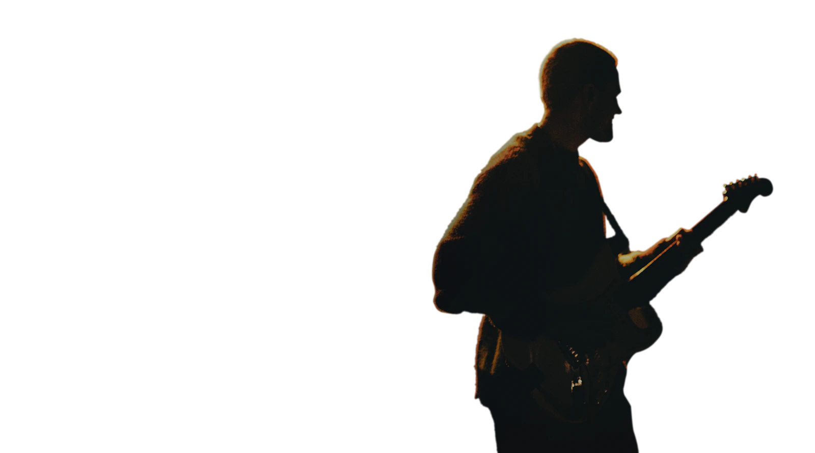 Guitarist performing on stage in warm orange light